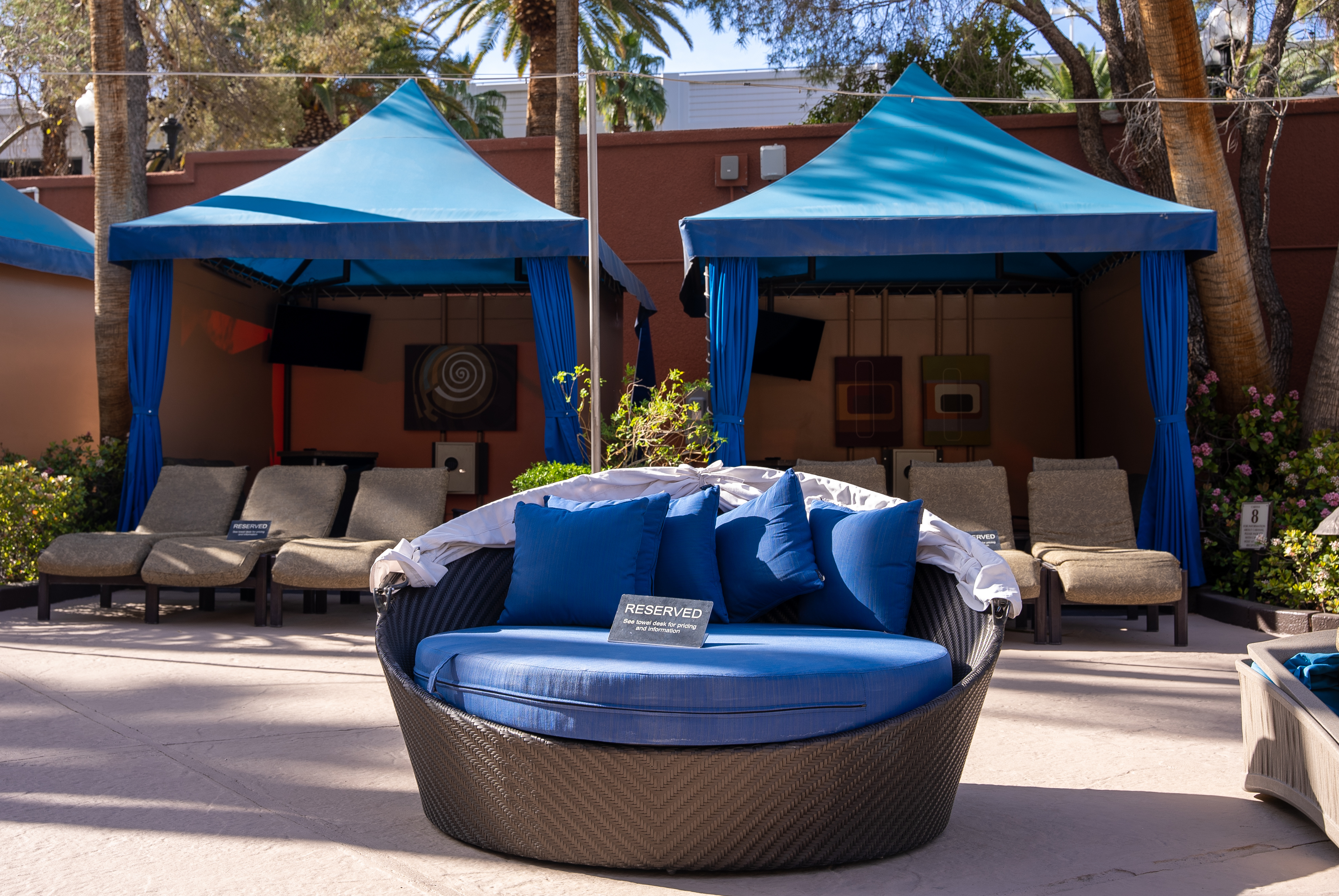 Daybed in front of two cabanas.